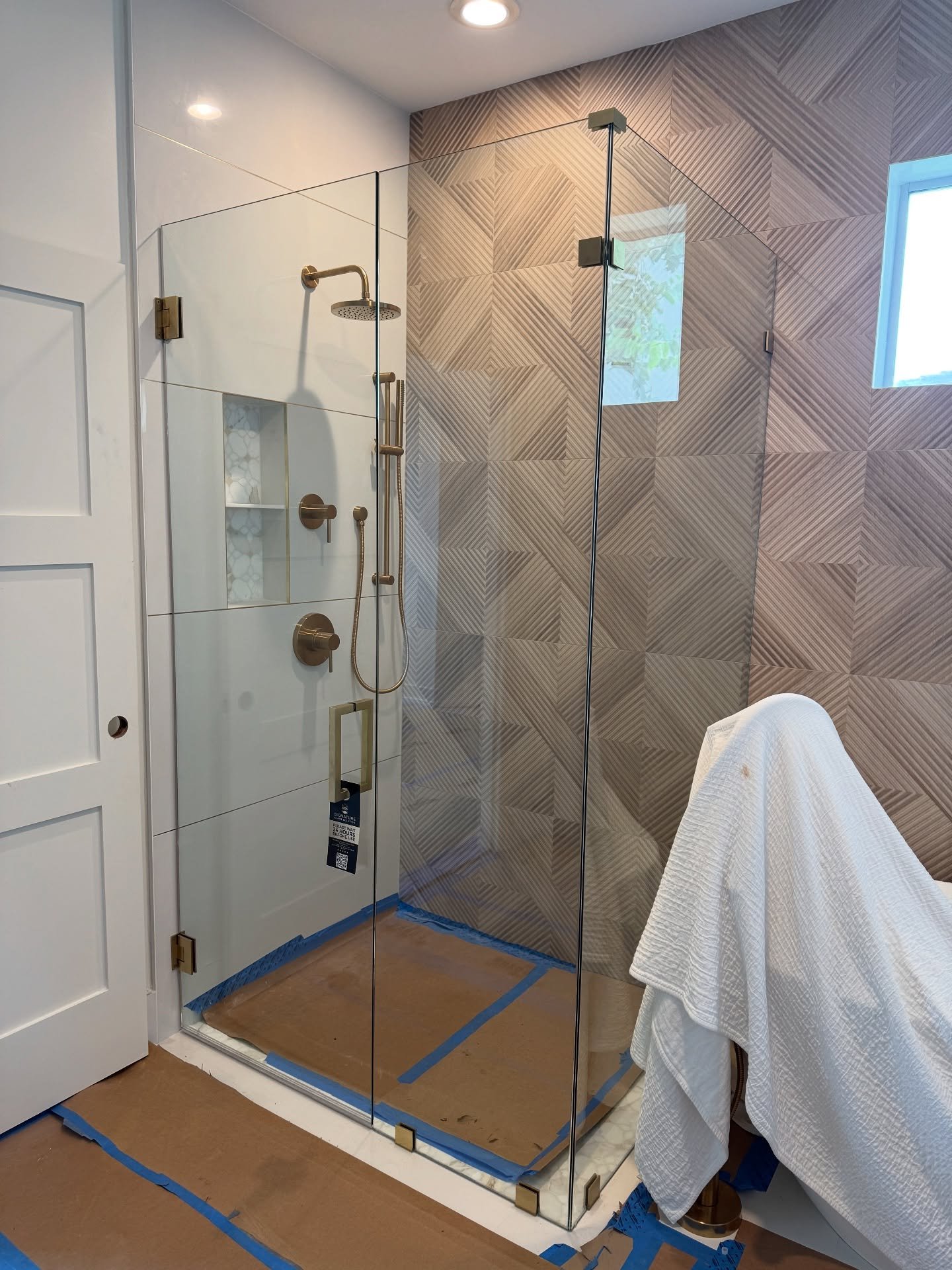 Clear corner shower enclosure with hinged door and fixed panels