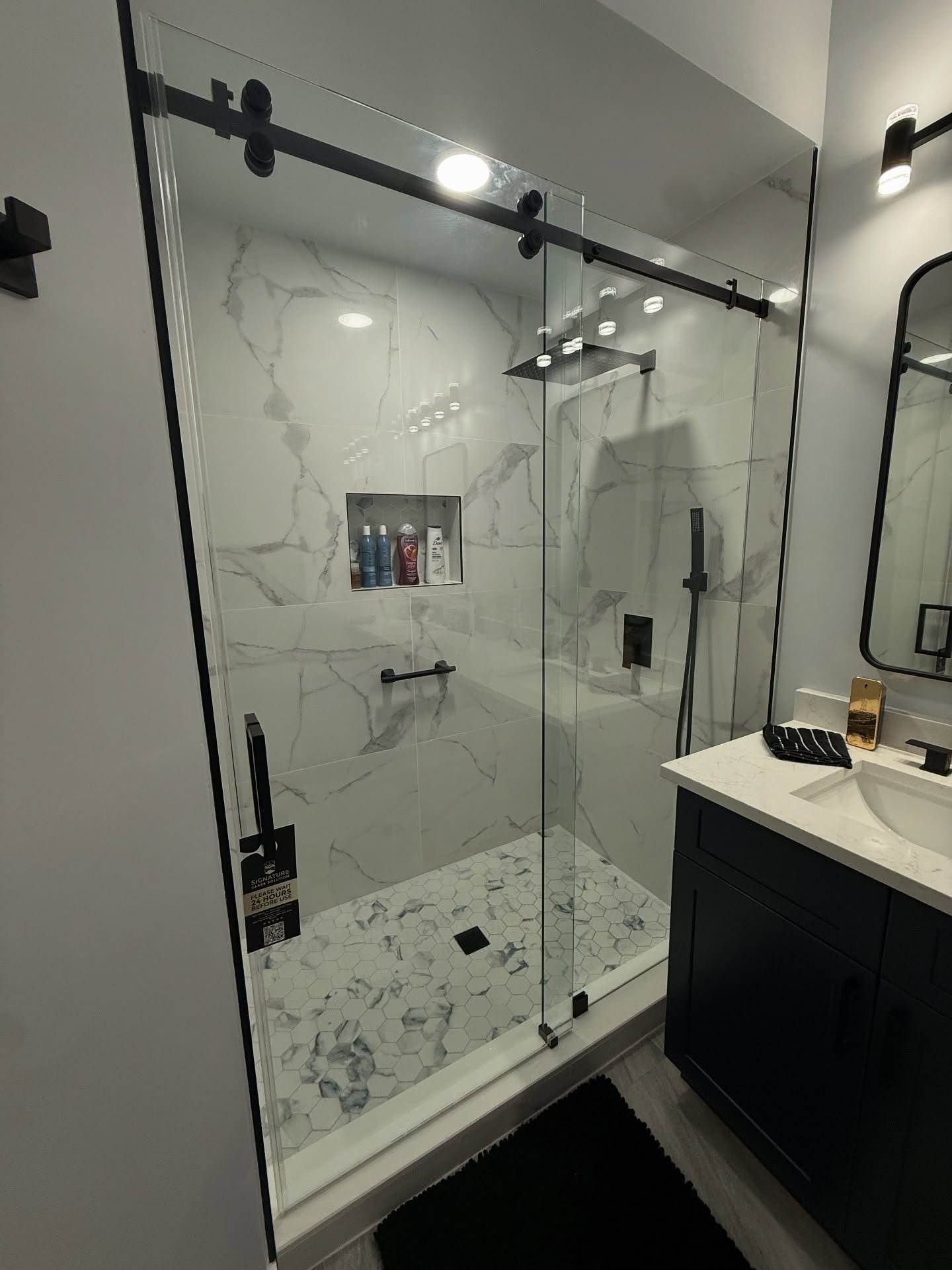 Sliding glass shower door with matte black track and hardware