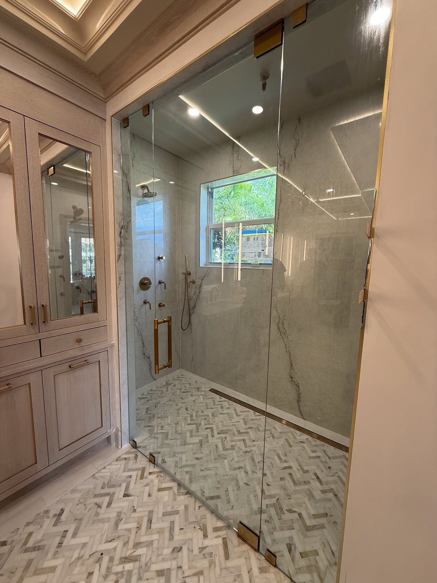 Wide frameless shower enclosure with gold handle and hinges